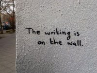 writing-is-on-the-wall-idiom-scaled.jpg